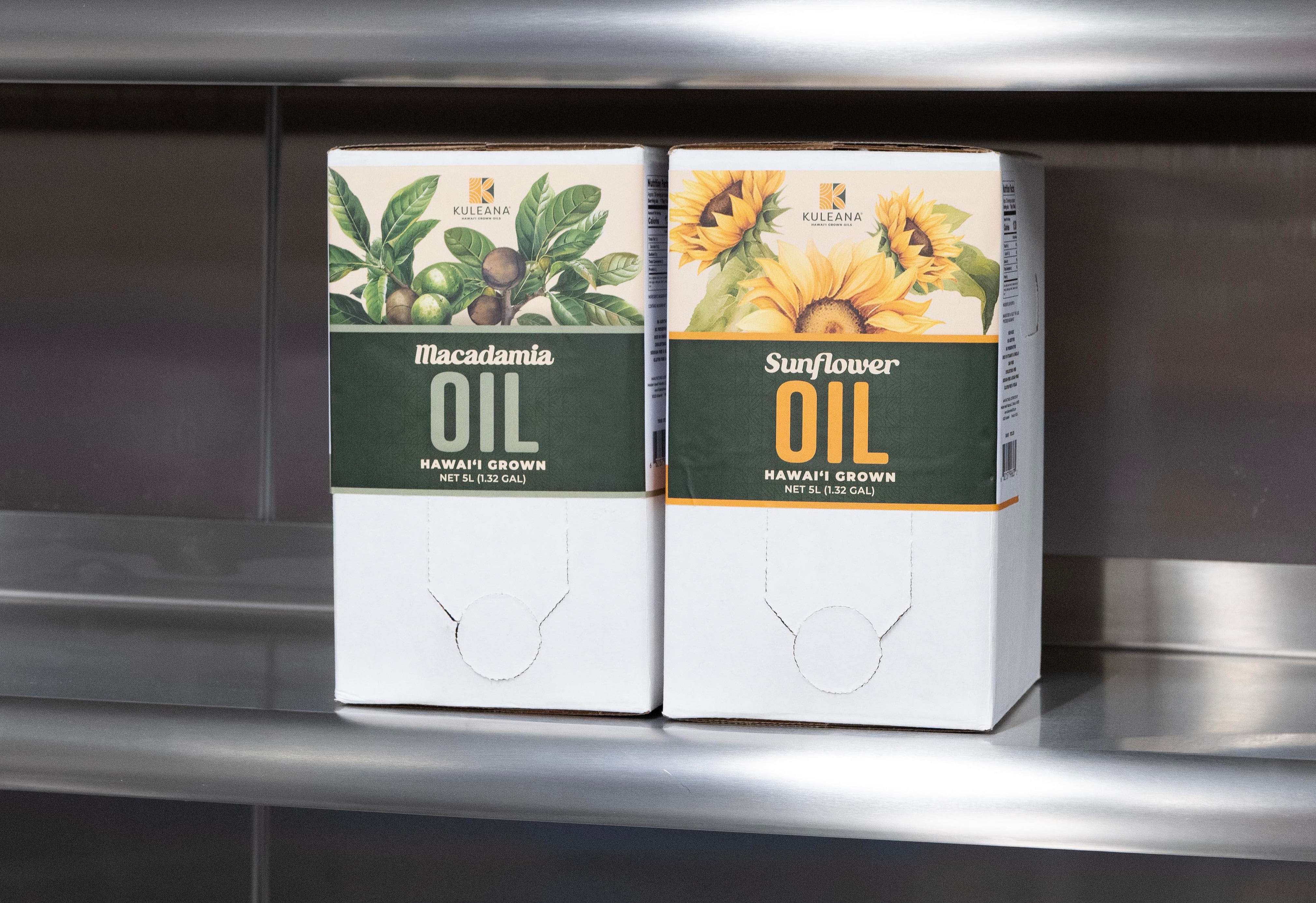 Two boxes of macadamia and sunflower oil on a metallic shelf.